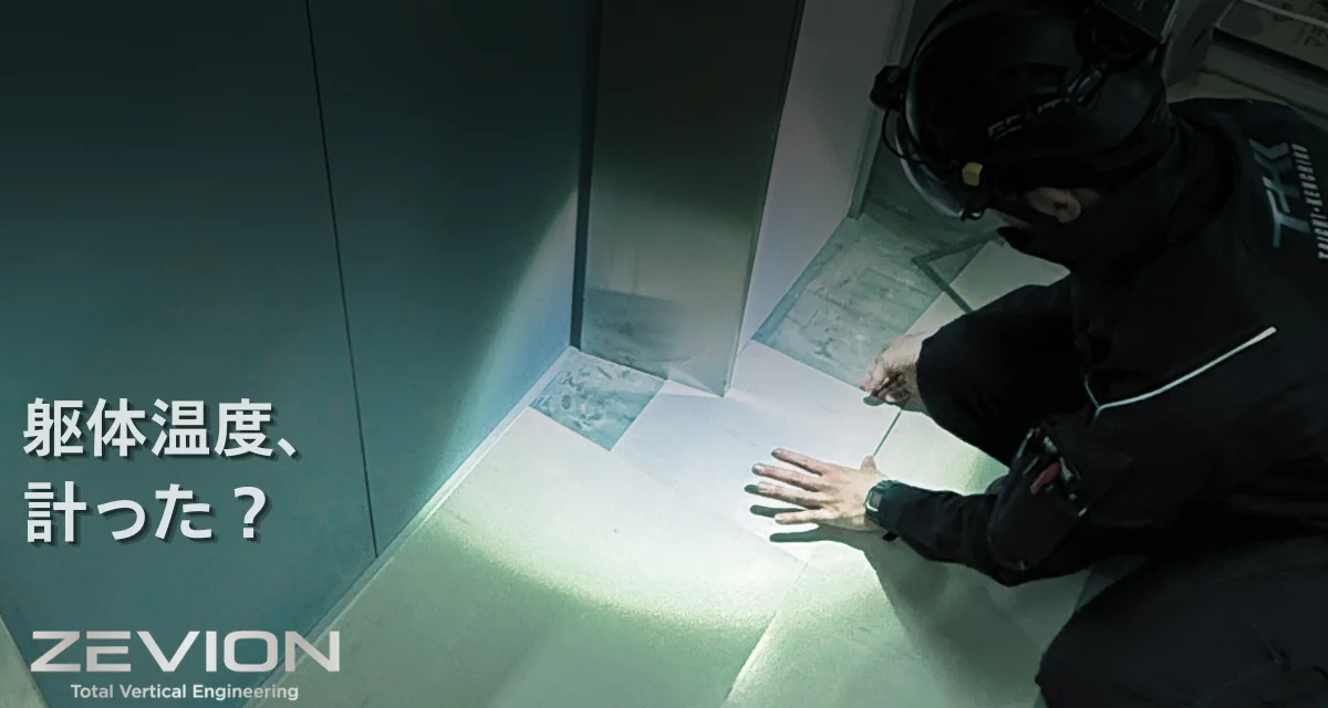 エレベーター乗場前で床タイルを施工する作業者