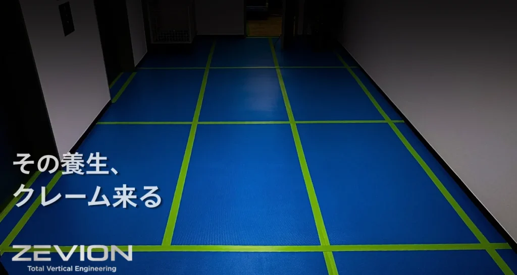 青い養生材を敷き、継ぎ目をテープで固定したエレベーターホールの床