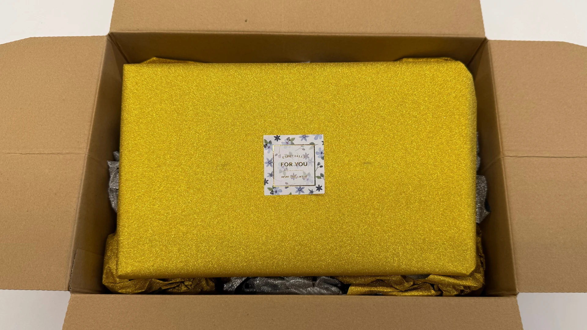 為廣社長から届いた金色の包装の誕生日プレゼント